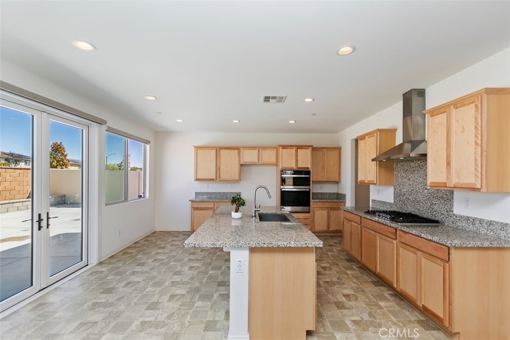 4521 Highland Avenue Perris, CA 92571 - Photo 17 of 54 a large kitchen with stainless steel appliances granite countertop a sink stove refrigerator and cabinets