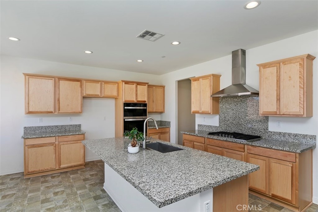 4521 Highland Avenue Perris, CA 92571 - Photo 19 of 54 a kitchen with stainless steel appliances granite countertop a stove sink and cabinets