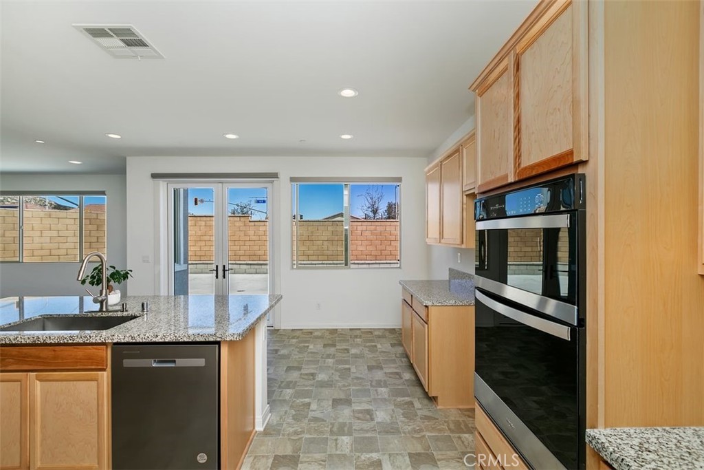 4521 Highland Avenue Perris, CA 92571 - Photo 21 of 54 a kitchen with granite countertop a refrigerator a sink and a stove