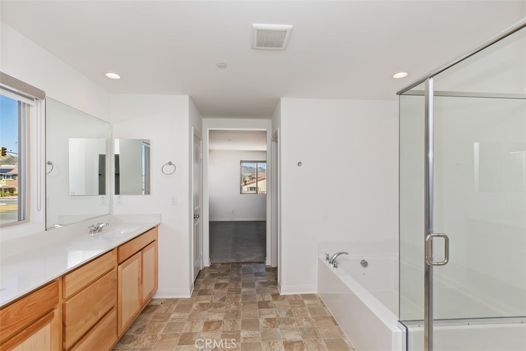 4521 Highland Avenue Perris, CA 92571 - Photo 38 of 54 a spacious bathroom with a bathtub shower sink and mirror