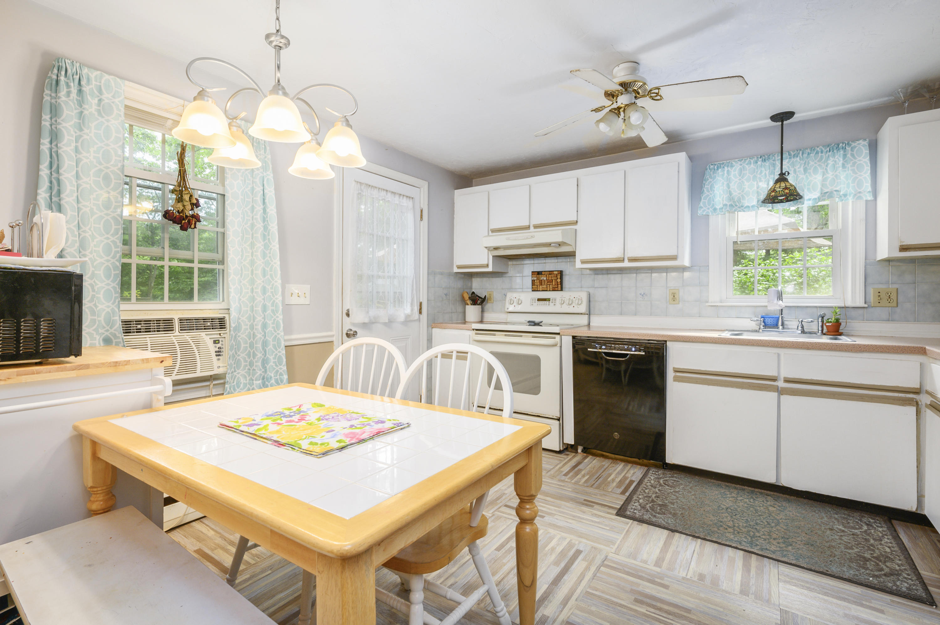 27 Oregon Road Mashpee, MA 02649 - Photo 9 of 17 a kitchen with a stove a sink a dining table and chairs
