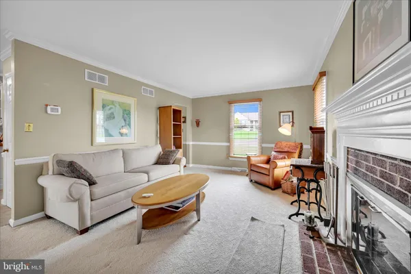 a living room with furniture a fireplace and a large window