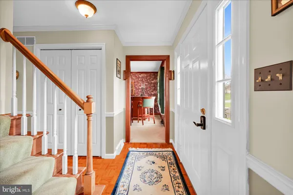 a view of a hallway with wooden floor and windows