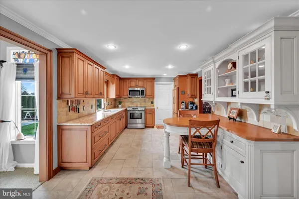 a large white kitchen with stainless steel appliances granite countertop a sink and cabinets