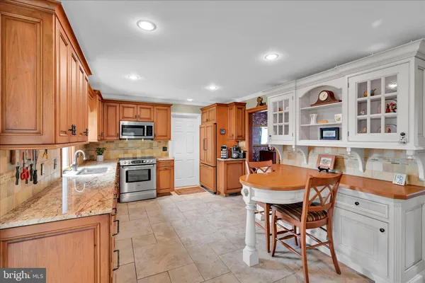 a kitchen with stainless steel appliances kitchen island granite top and refrigerator