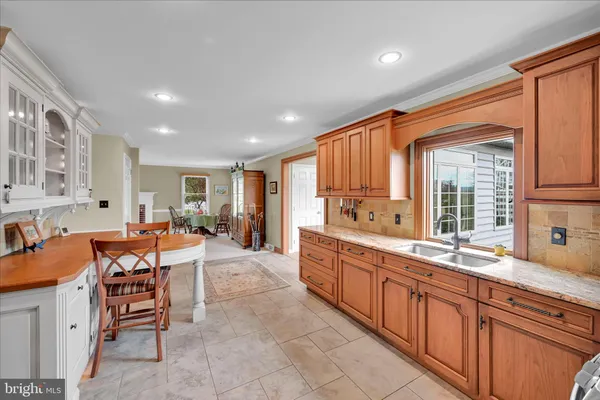 a large kitchen with stainless steel appliances granite countertop a sink and a refrigerator