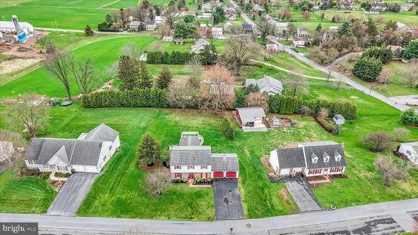 an aerial view of residential houses with outdoor space and street view