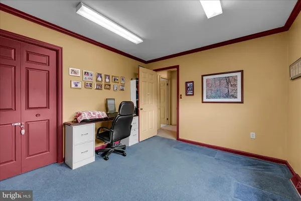 a view of a workspace with furniture and a window