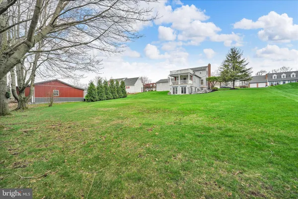 a view of a house with a big yard and a large tree