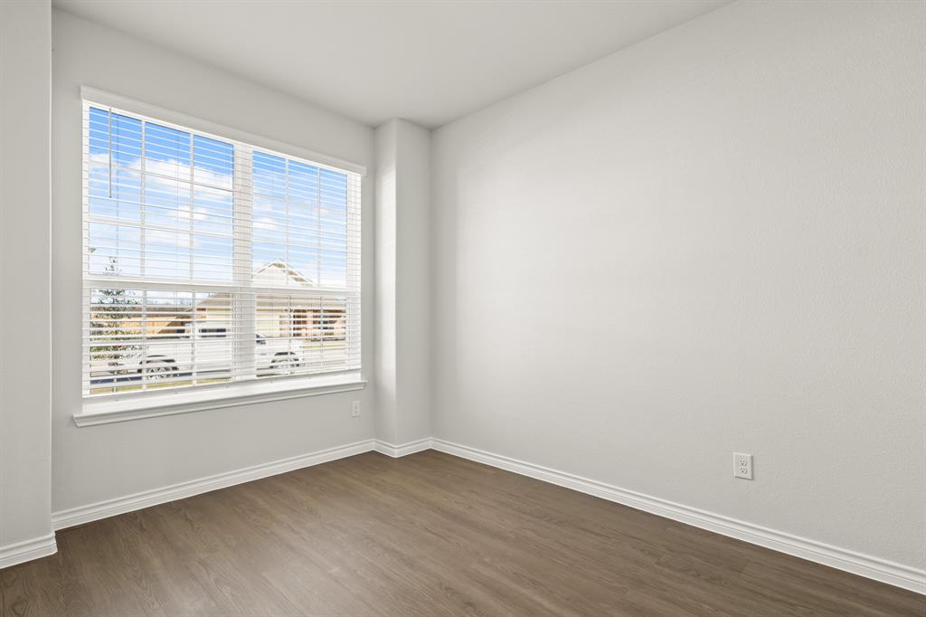 5025 Wellborn Road Crowley, TX 76036 - Photo 4 of 38 an empty room with wooden floor and windows