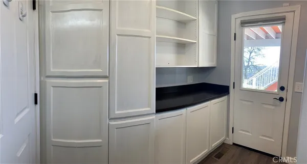 a backyard of a house with table and chairs under an umbrella