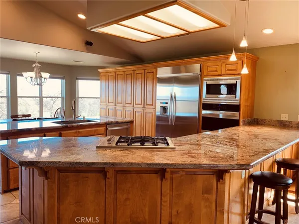 a living room with furniture kitchen view and a large window
