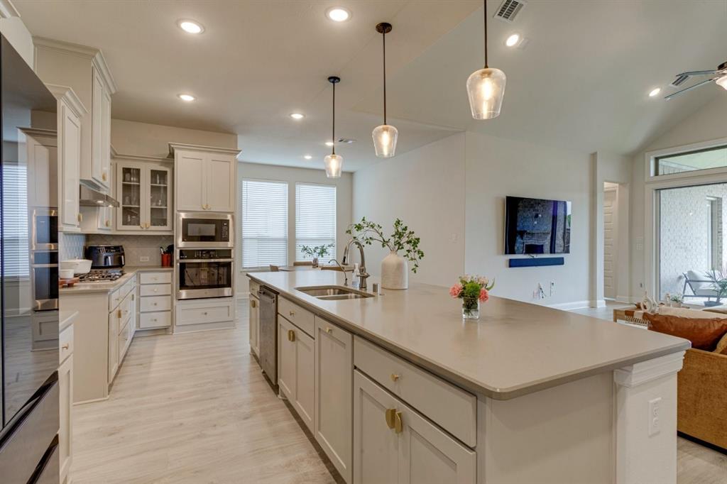9613 Boulder Pt Road Oak Point, TX 75068 - Photo 9 of 28 Open-concept kitchen featuring an expansive central island with an undermount sink, integrated dishwasher, and pendant lighting