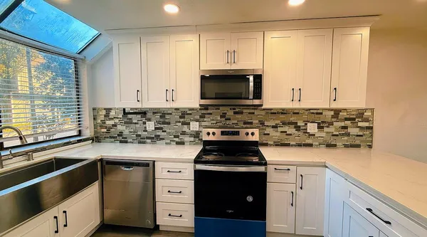 a kitchen with granite countertop a sink and a stove top oven