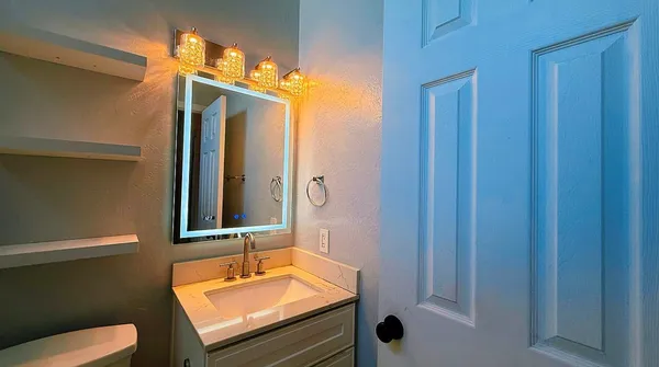 a bathroom with a sink a toilet and shower