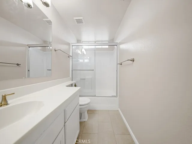 a bathroom with a shower a sink and a toilet