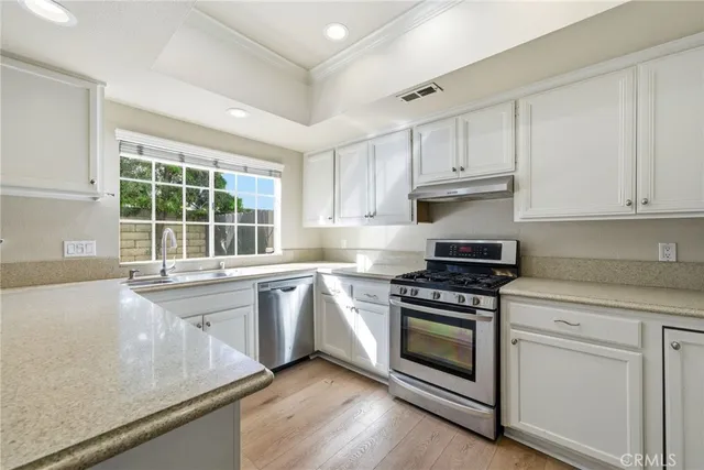 a kitchen with granite countertop white cabinets and appliances