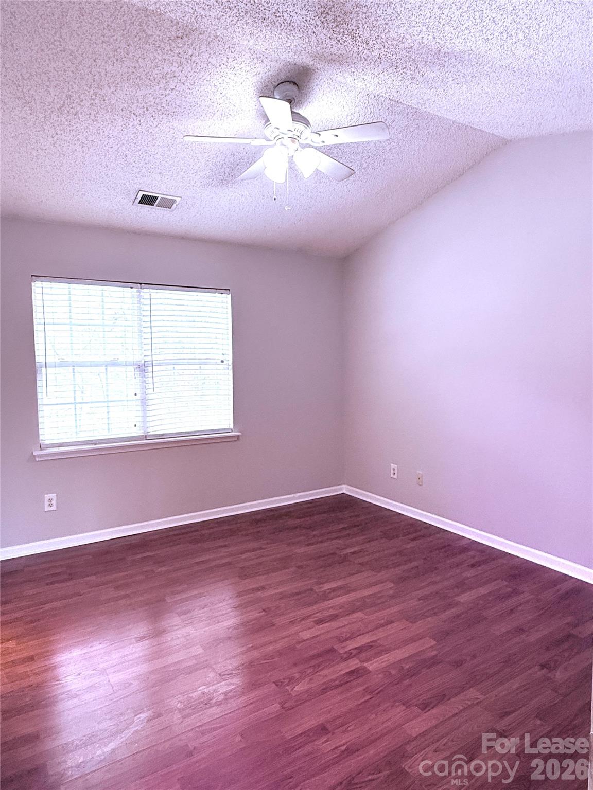 11519 Retriever Way Charlotte, NC 28269 - Photo 5 of 11 an empty room with windows and a ceiling fan