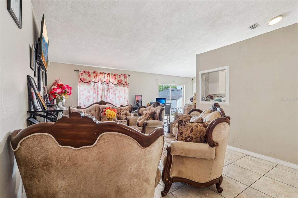 42 Inconnu Drive Poinciana, FL 34759 - Photo 12 of 29 a living room with furniture a couch and a flat screen tv