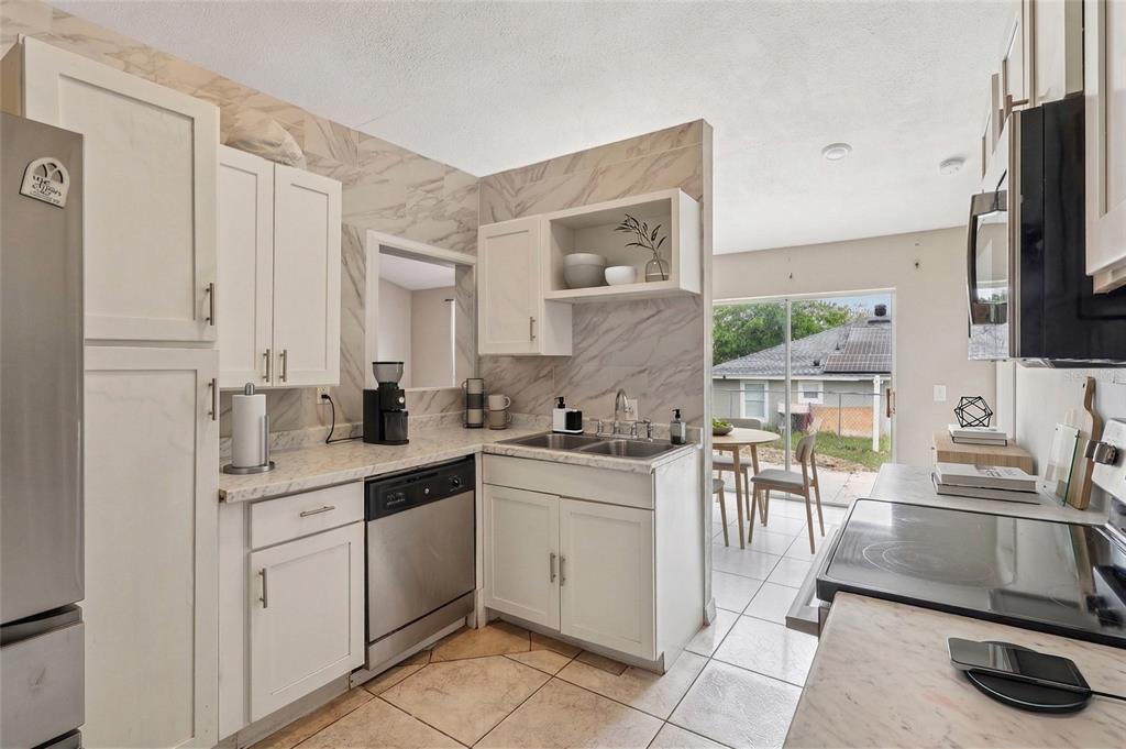 42 Inconnu Drive Poinciana, FL 34759 - Photo 13 of 29 a kitchen with a sink stainless steel appliances and cabinets