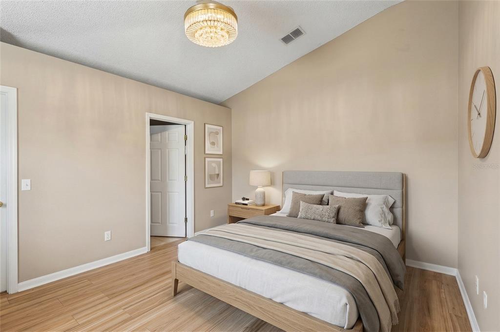 42 Inconnu Drive Poinciana, FL 34759 - Photo 15 of 29 a bedroom with a bed and a chandelier