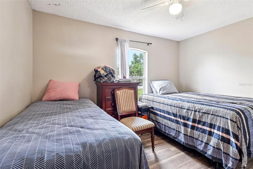 42 Inconnu Drive Poinciana, FL 34759 - Photo 18 of 29 a bedroom with a bed and wooden floor