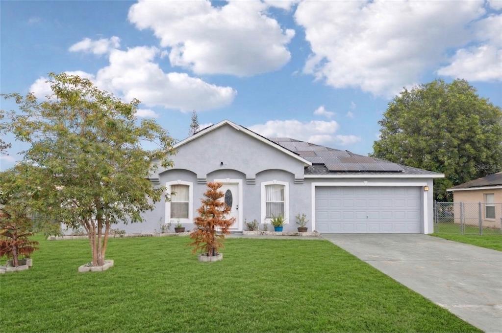42 Inconnu Drive Poinciana, FL 34759 - Photo 3 of 29 a front view of a house with a garden