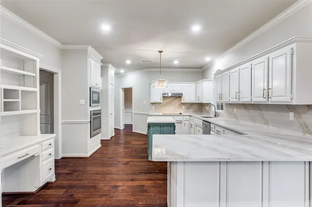 a kitchen with stainless steel appliances granite countertop a refrigerator a sink dishwasher a stove and white cabinets with wooden floor