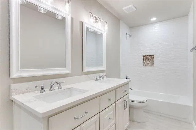 a bathroom with a sink double vanity granite toilet tub and shower