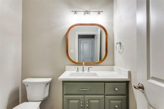a bathroom with a toilet sink and mirror