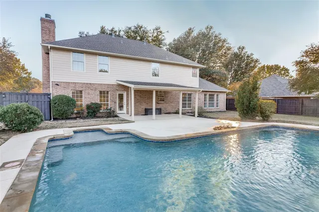 a view of house with swimming pool and a yard