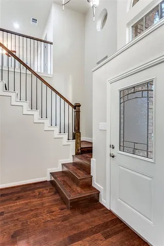 a view of a hallway with wooden floor and staircase