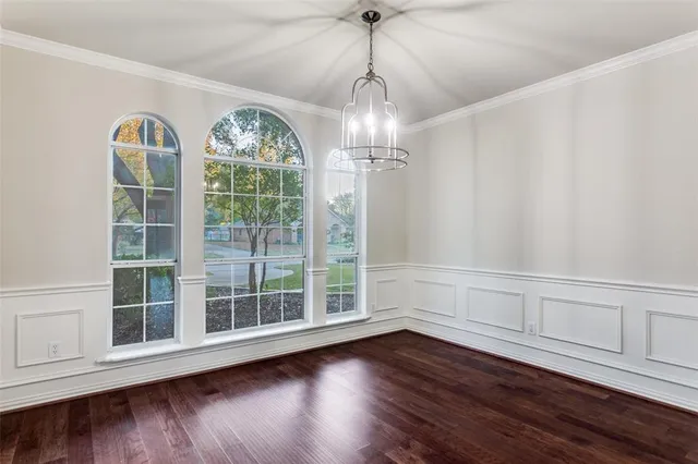 a view of wooden floor chandelier and entryway in a room