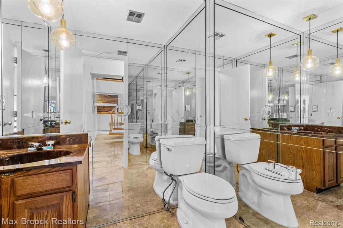 1830 Lone Pine Road Bloomfield Hills, MI 48302 - Photo 31 of 70 Powder Room Mirrored wall and ceiling, toilet, a bidet, and a vanity with a dark countertop