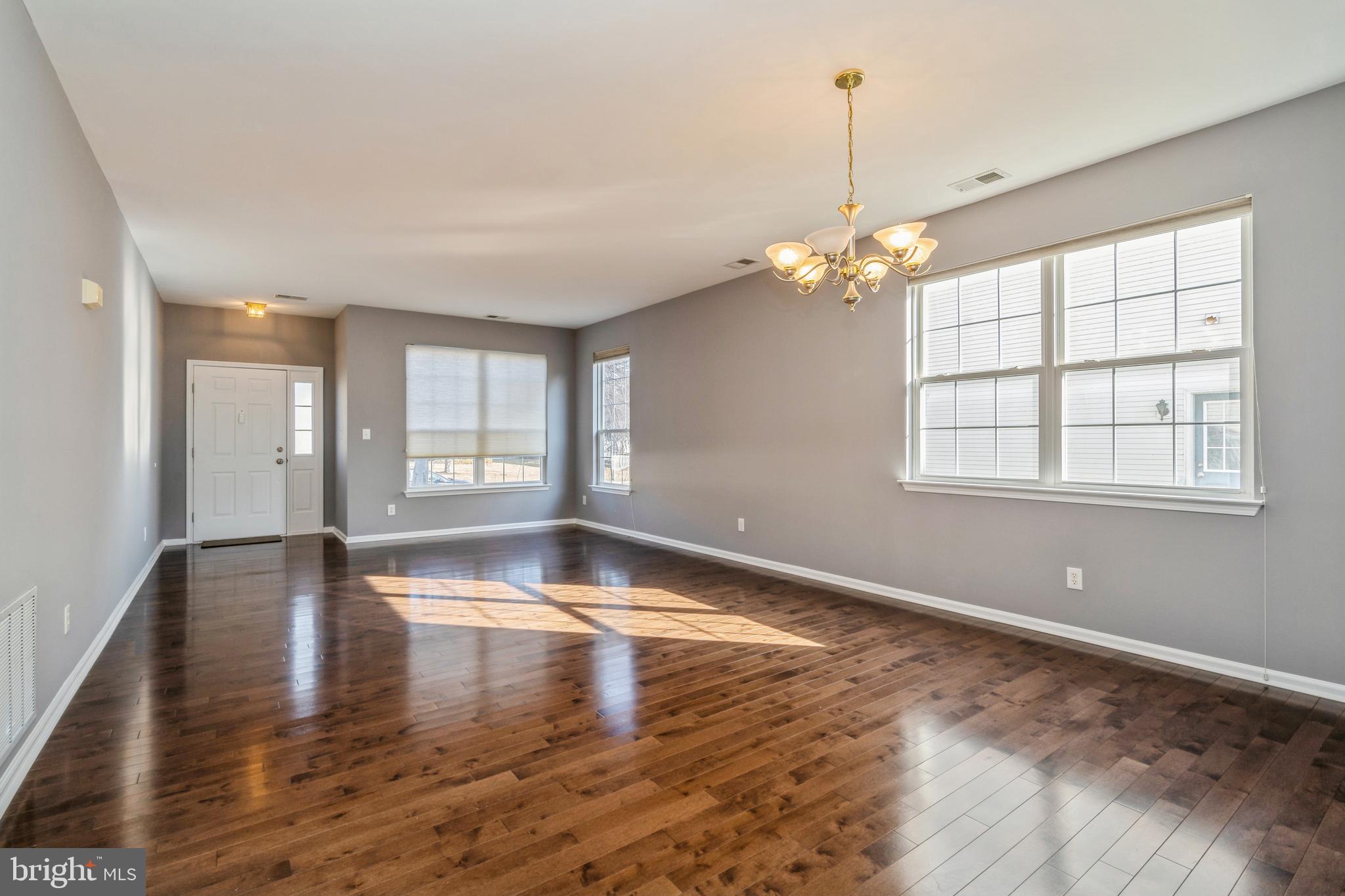 26 Manley Road Pennington, NJ 08534 - Photo 3 of 38 a view of an empty room with window and wooden floor