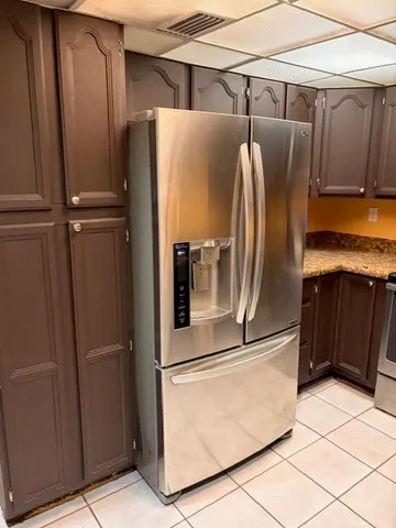 a metallic refrigerator freezer sitting in a kitchen