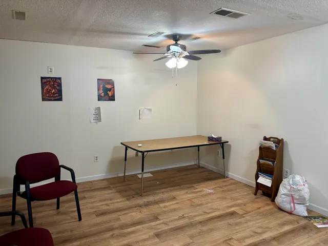 a view of a workspace with furniture and wooden floor