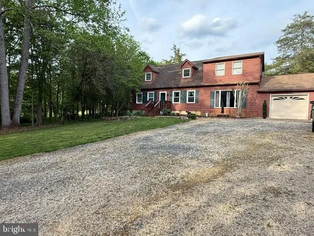 a view of a big house with a big yard and large trees