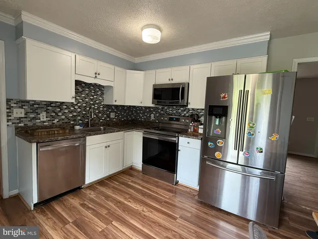 a kitchen with a refrigerator stove and sink