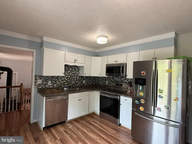 a kitchen with stainless steel appliances a refrigerator sink and stove