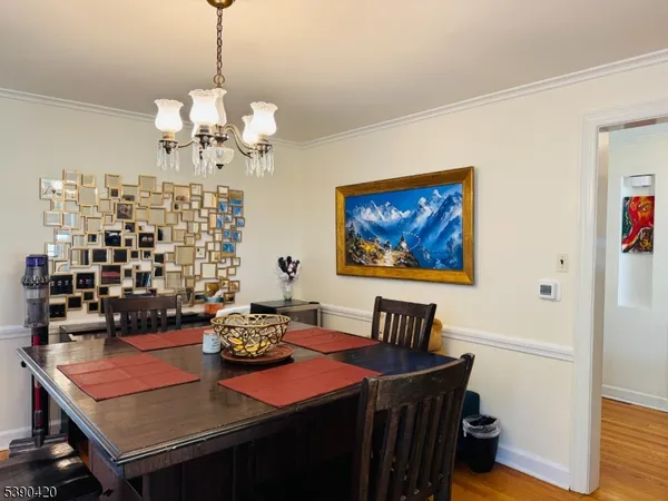 a view of a dining room with furniture a chandelier and wooden floor