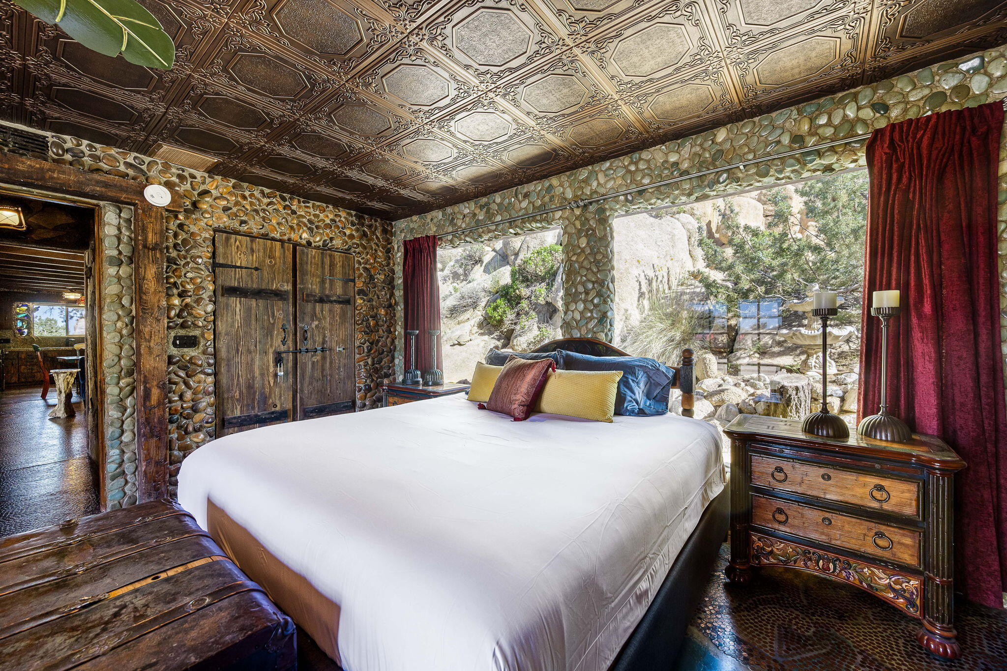 5845 Cholla Avenue Yucca Valley, CA 92284 - Photo 29 of 75 a bedroom with a bed next to a large window with the outer view