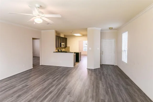 a view of a kitchen with wooden floor and a ceiling fan