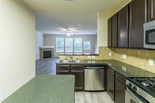 a kitchen with stainless steel appliances granite countertop a stove a sink and a microwave