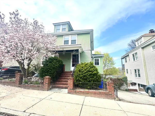 a front view of a house with a tree