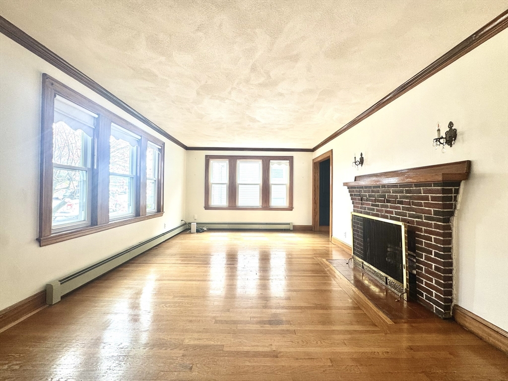 53 Breck Avenue Boston, MA 02135 - Photo 12 of 35 a view of an empty room with wooden floor and a window