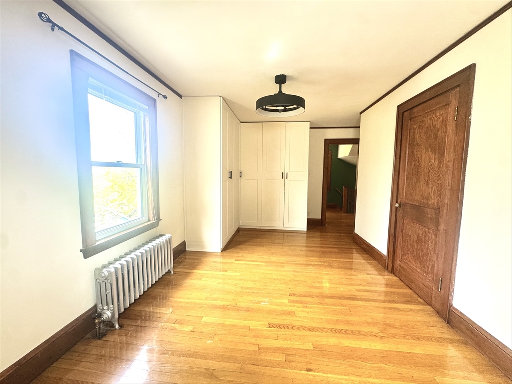53 Breck Avenue Boston, MA 02135 - Photo 19 of 35 a view of a hallway to a room with wooden floor and staircase