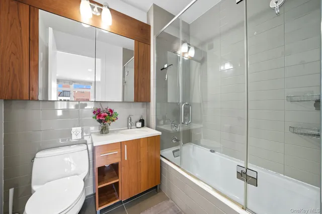 a bathroom with a granite countertop sink mirror toilet and bathtub