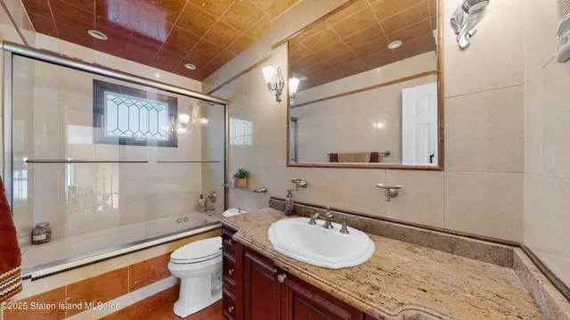 a bathroom with a granite countertop sink mirror and a shower