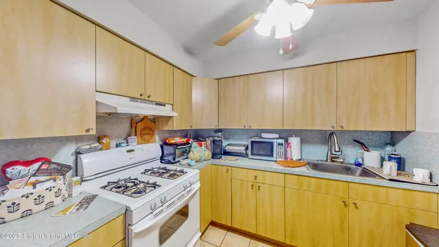 a kitchen with stainless steel appliances a stove a sink dishwasher and cabinets with wooden floor